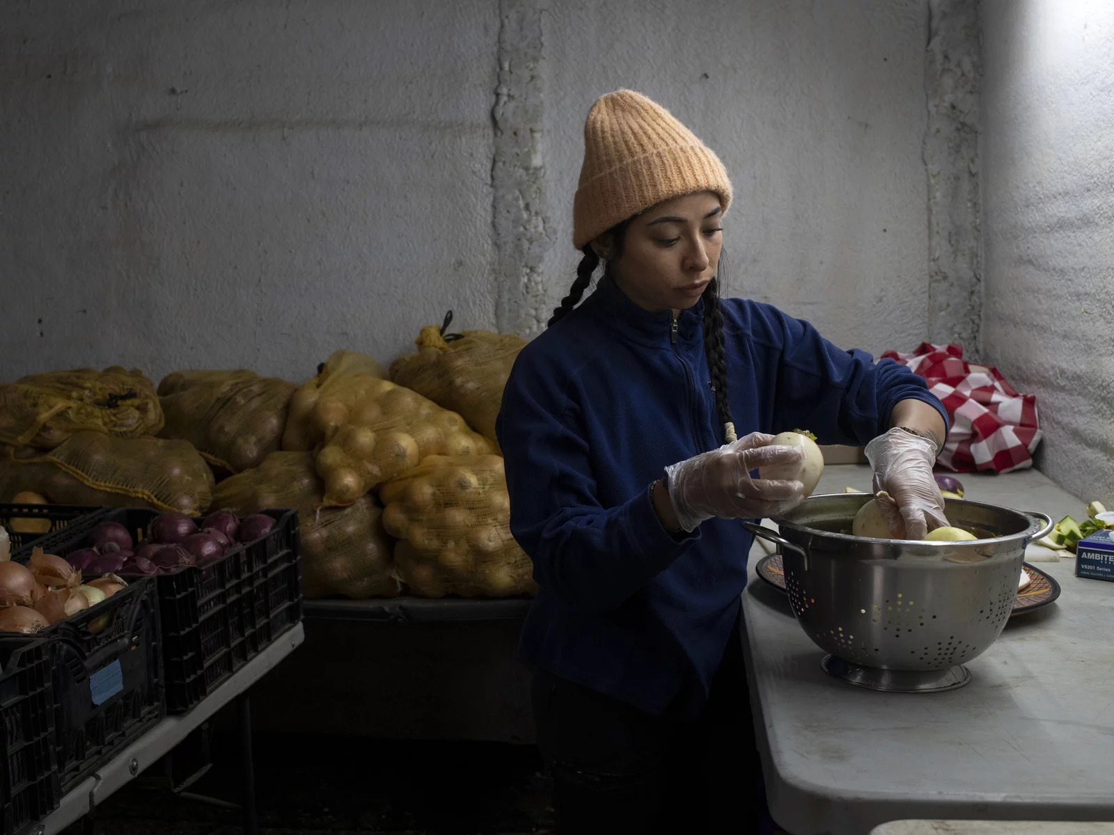 Woman putting produce in a metal bowl