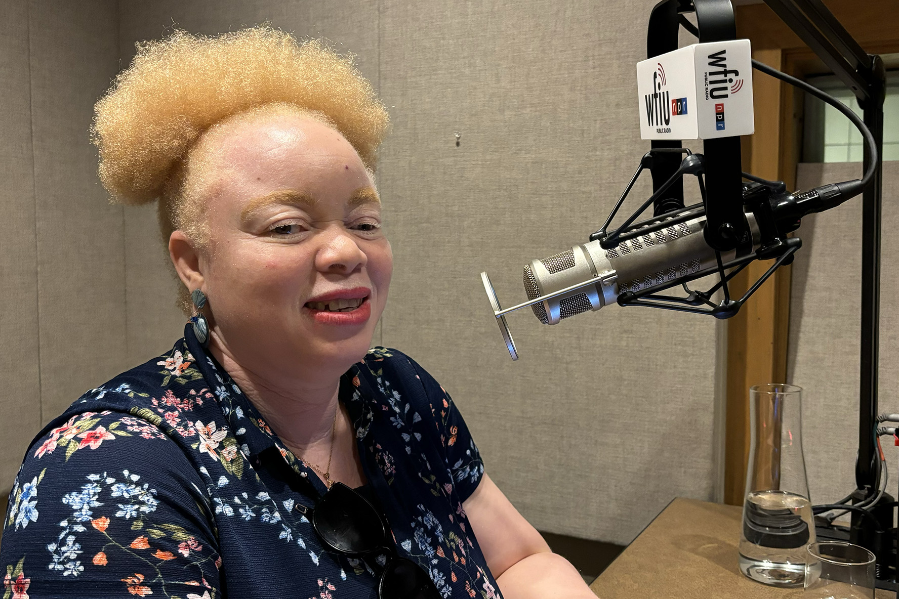 Funmi Ayeni headshot  in recording studio with microphone with WFIU