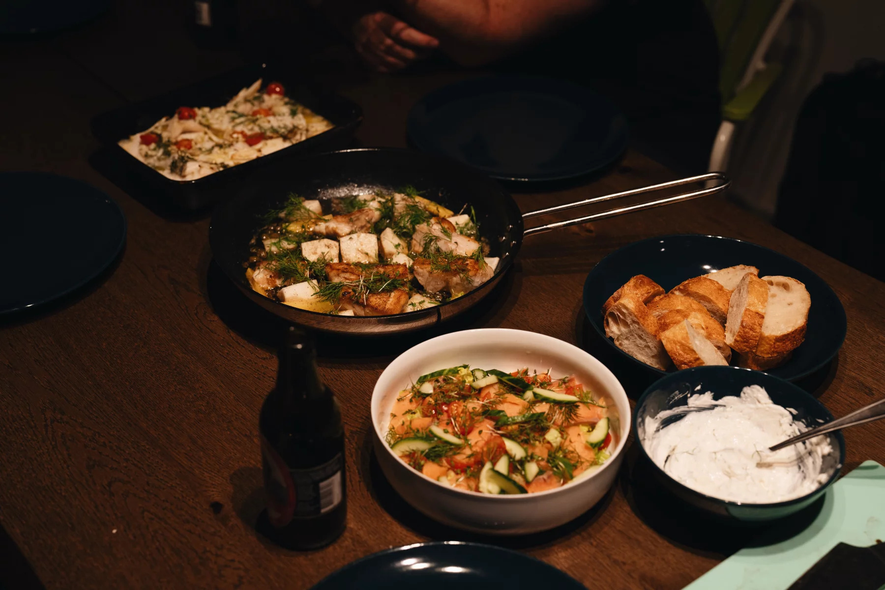 five dishes served in black bowls on a wooden table