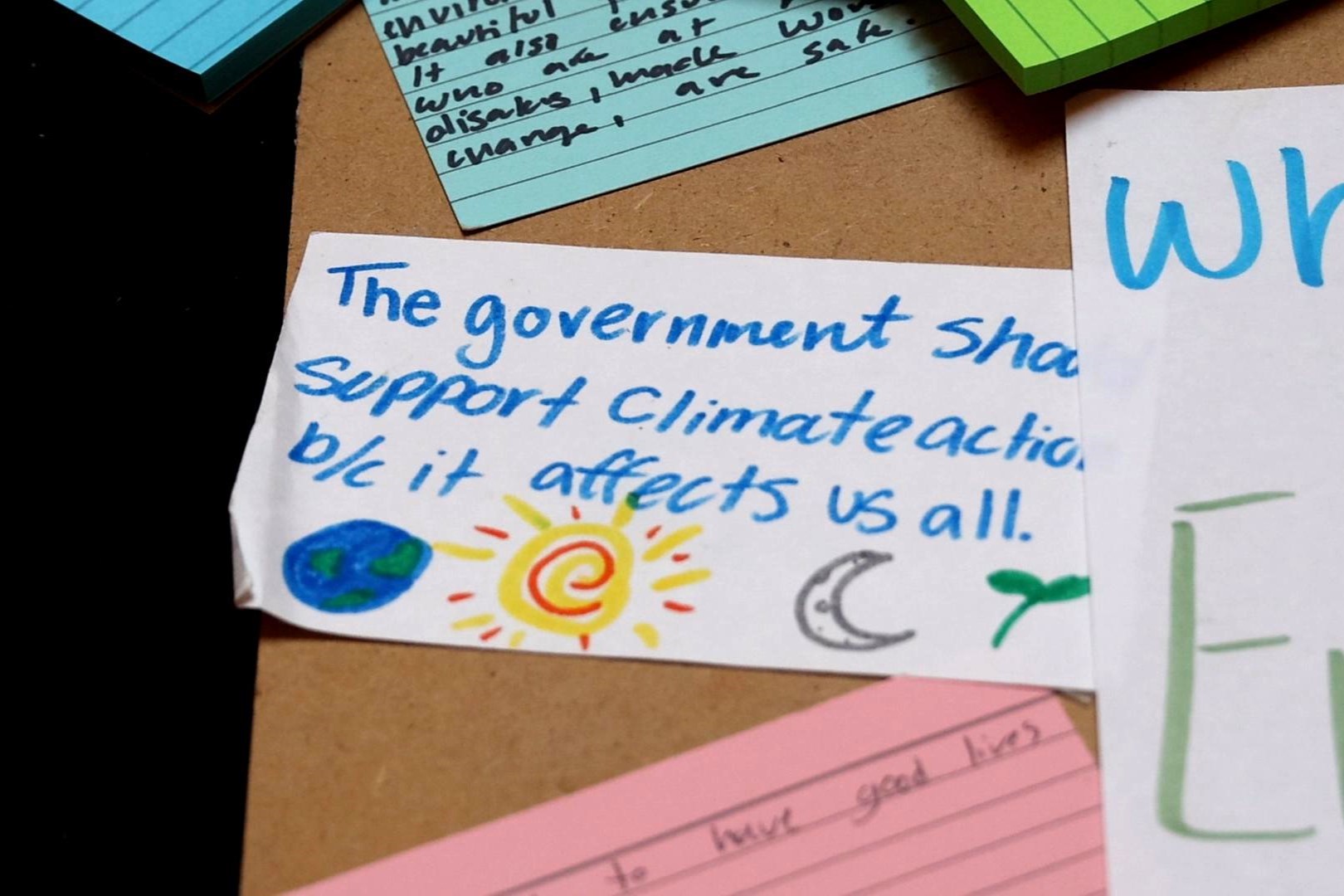 A notecard at the Confront the Climate Crisis event March 17, 2025 at the statehouse reads "The government should support climate action b/c it affects us all."