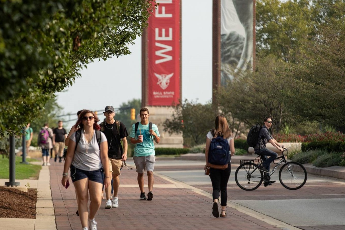 Students walk outside on a warm day at the Ball State University campus.