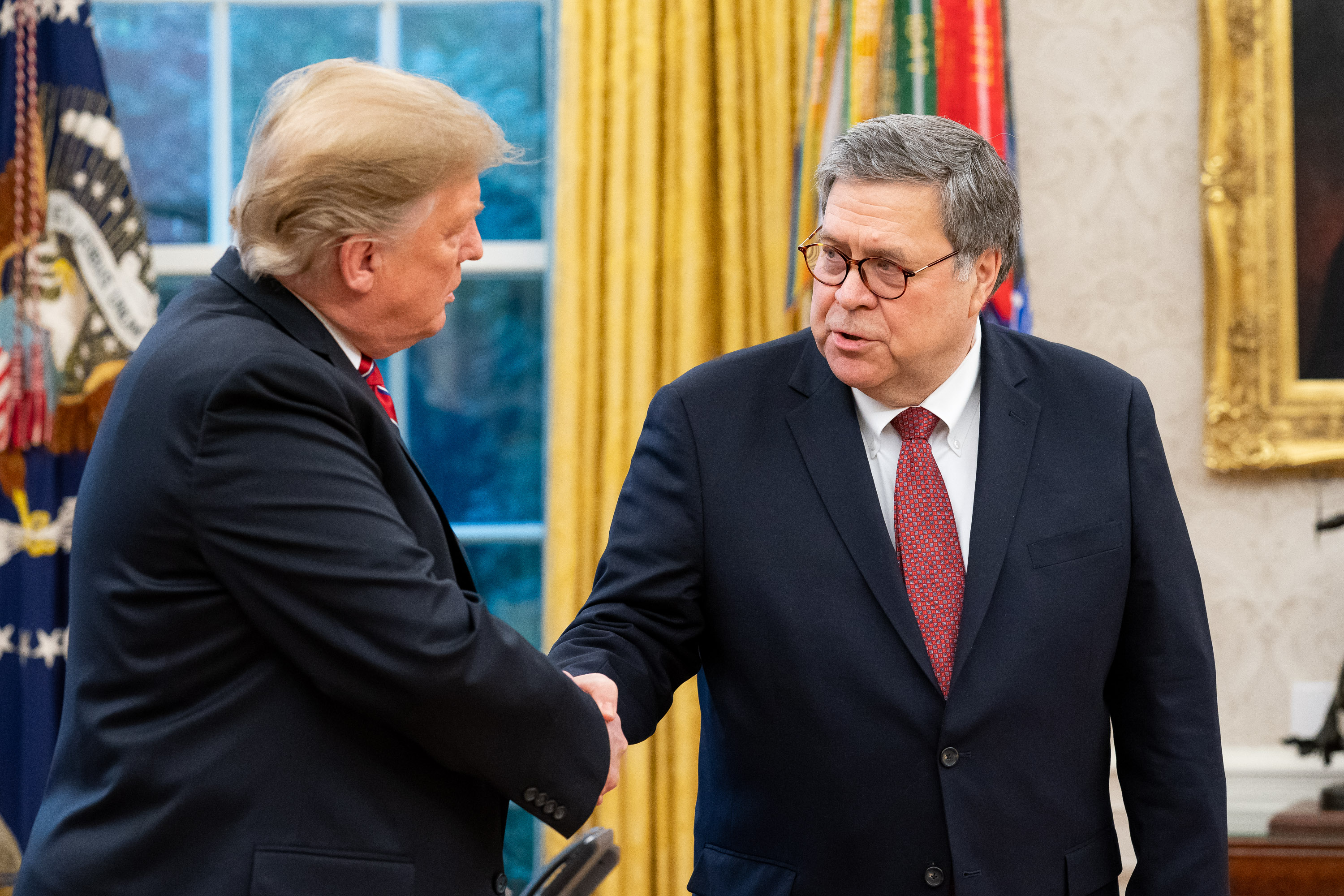 President Donald Trump and U.S. Attorney General William Barr shake hands in the Oval Office.