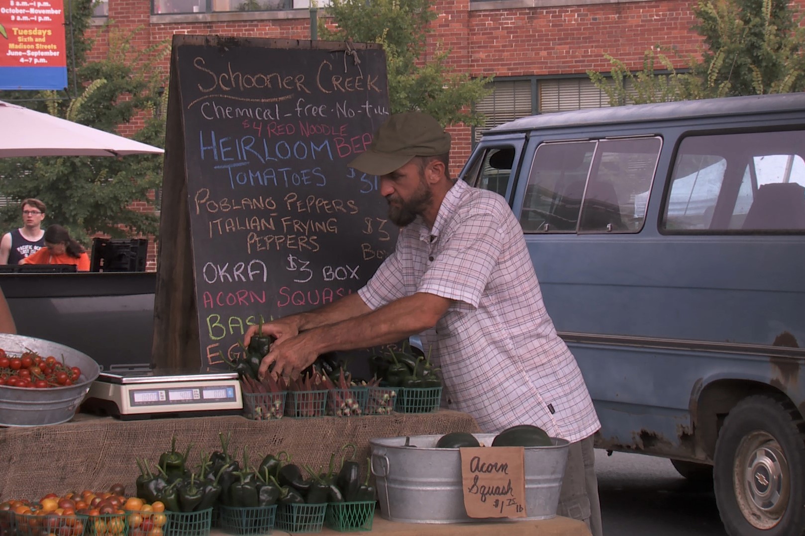 Doug Mackey works at the Schooner Creek Farm booth at the Bloomington Community Farmers' Market, Aug. 17, 2019.