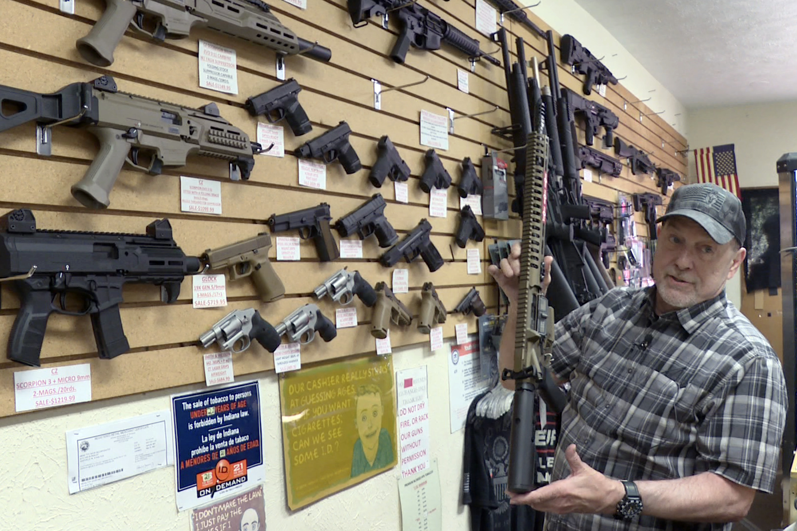 Gun shop owner Mike Strausburg with rifle