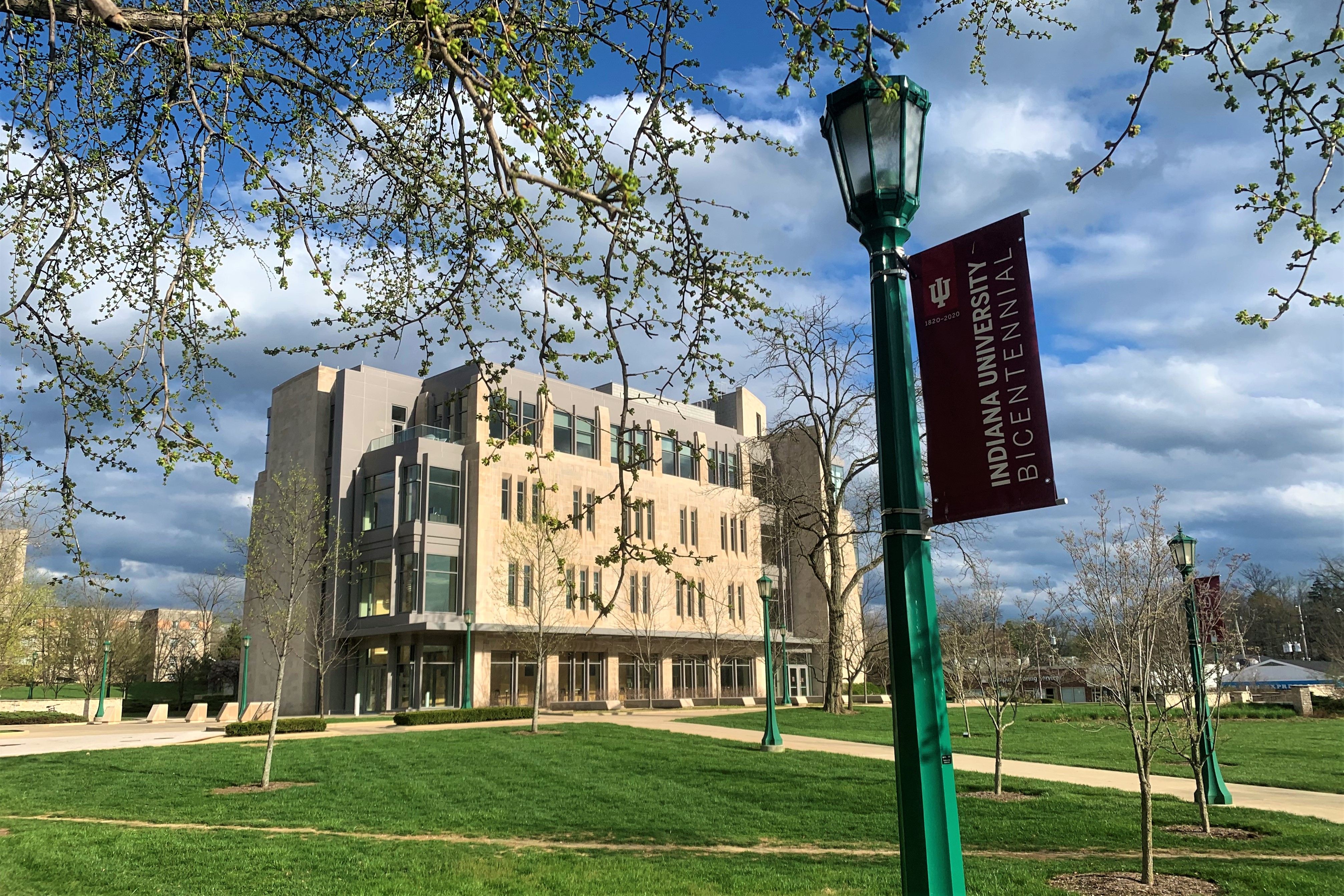 Students walk outside on a warm day at the Ball State University campus.