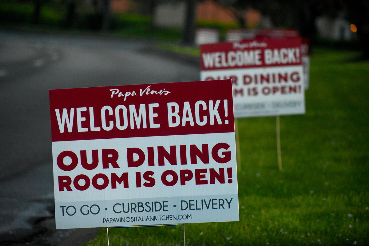 Signs advertising a restaurant reopening after local coronavirus stay-at-home restrictions are lifted.