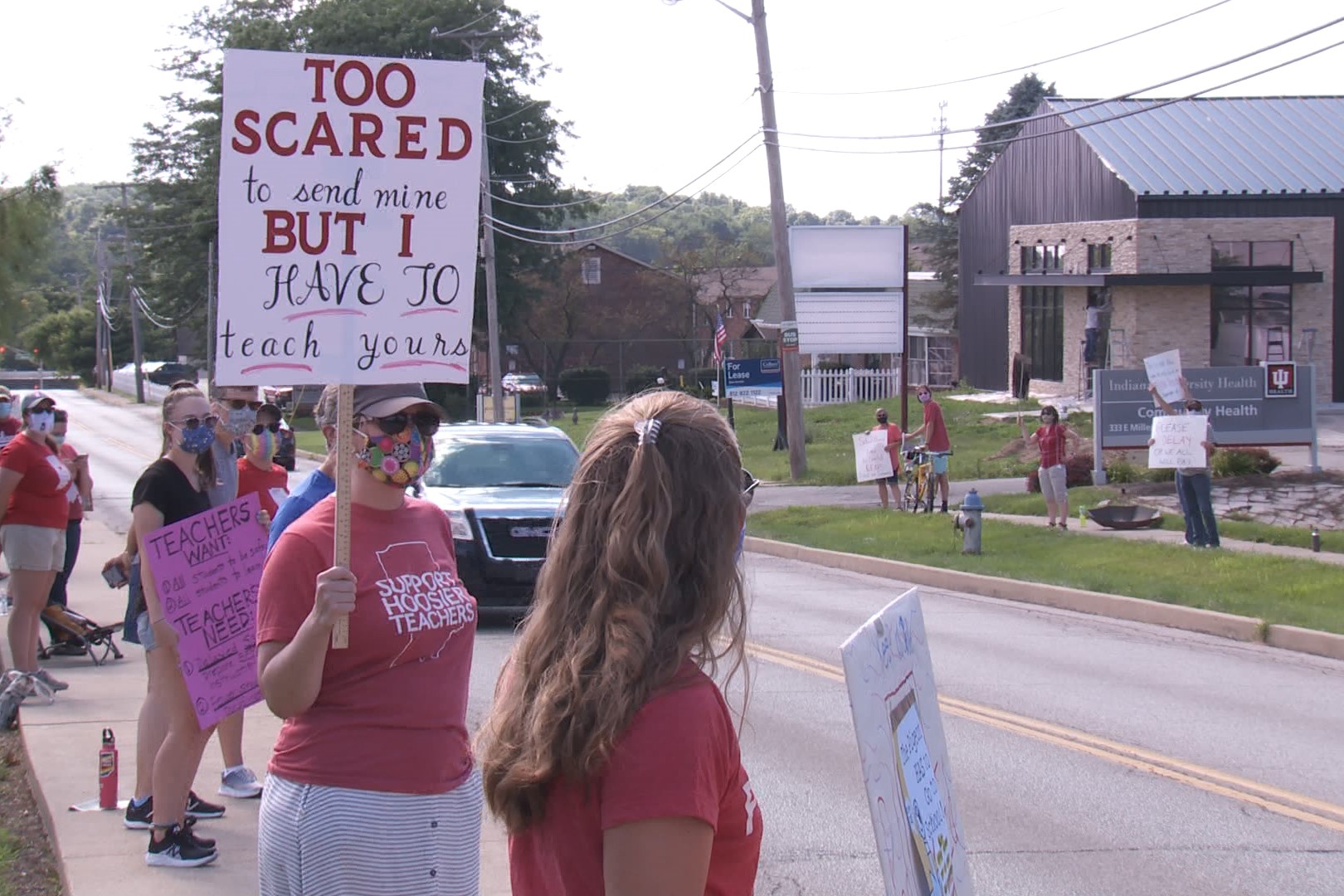 A picture of teachers and parents protesting to push back the school start date due to COVID-19.