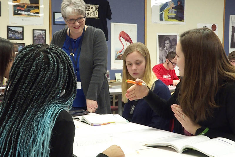 A teacher listens to student questions during an in class project in Kokomo.