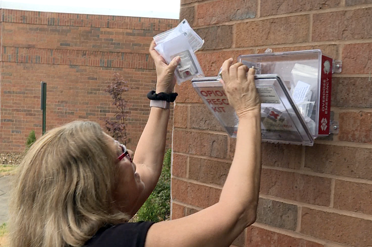 Evansville Recovery Alliance Karen Warpenburg refills a NaloxBox.