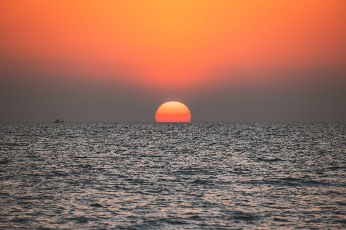 Sundown Above Sea Horizon At Sunset. Natural Sunrise Sky Warm Colors Over Ocean