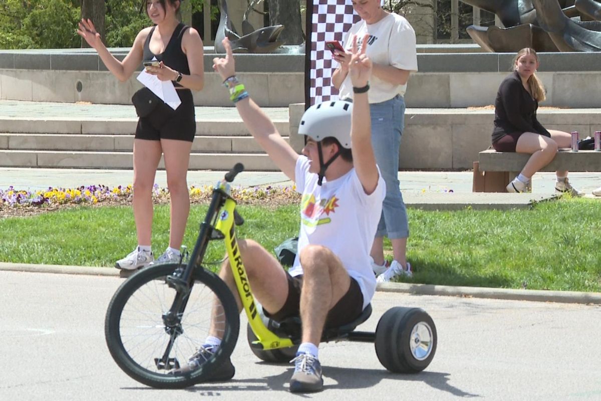 A racer in the Little Little 499 celebrates after crossing the chalk-marked finish line at Showalter Fountain April 23, 2025.