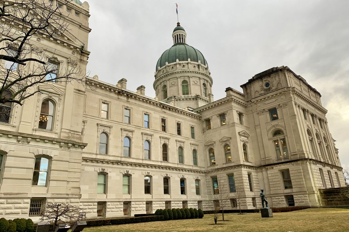 The Indiana Statehouse sits underneath a cloudy sky.