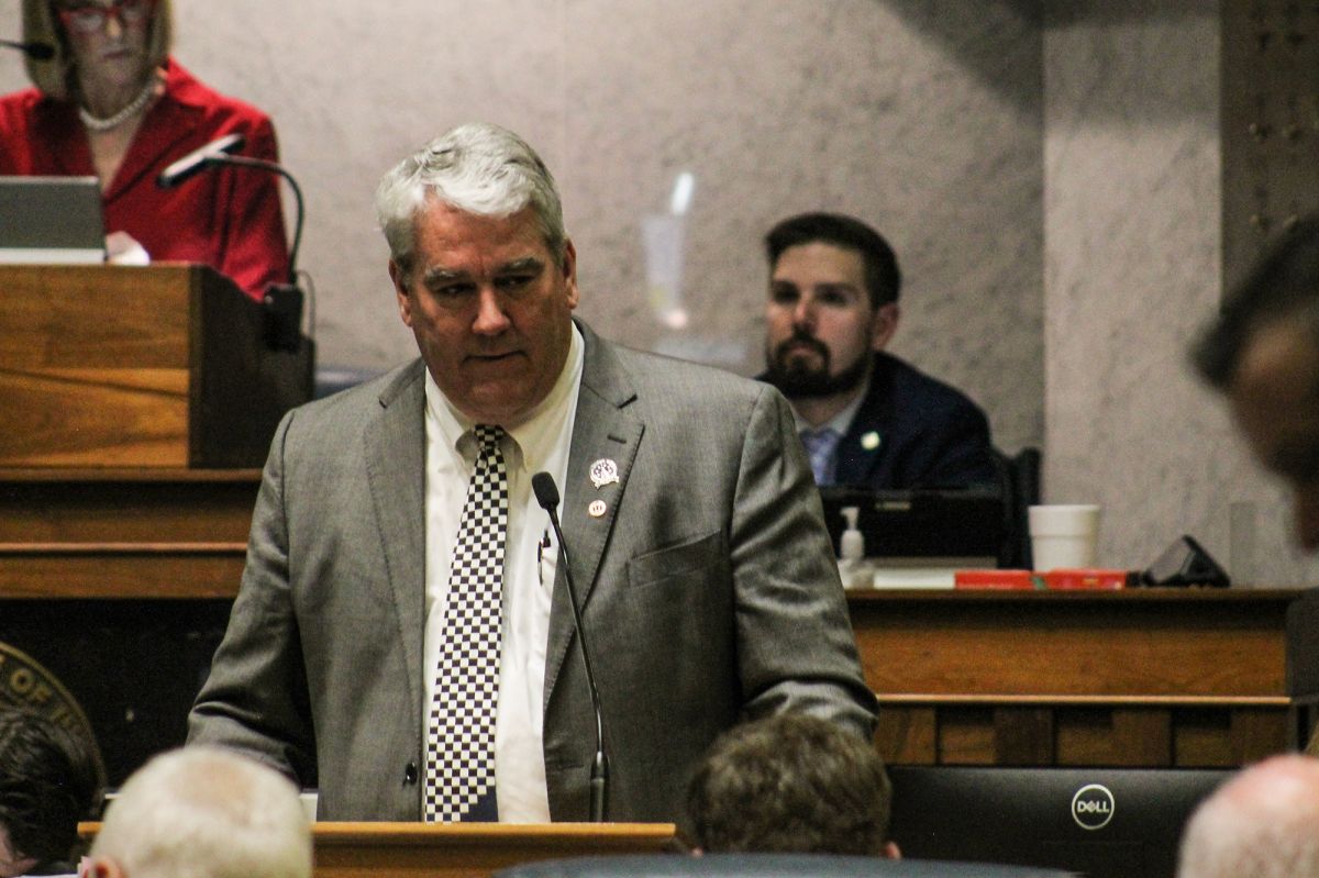 Senator Andy Zay speaks at a podium on the Senate floor. He is a White man with grey hair. 
