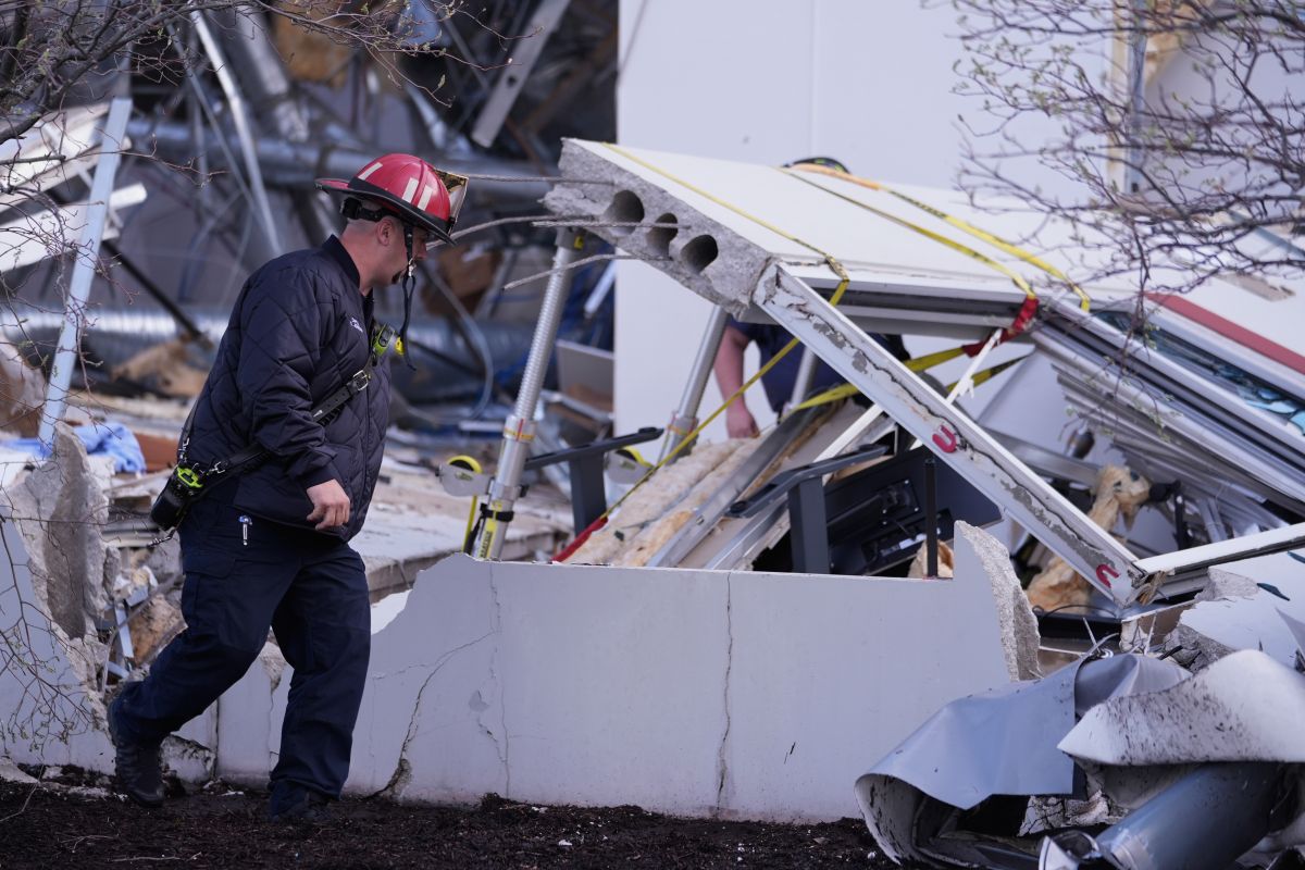 AP OK - Brownsburg firefighters survey storm damage to a warehouse in Brownsburg, Ind., Thursday, April 3, 2025. (AP Photo/Michael Conroy)