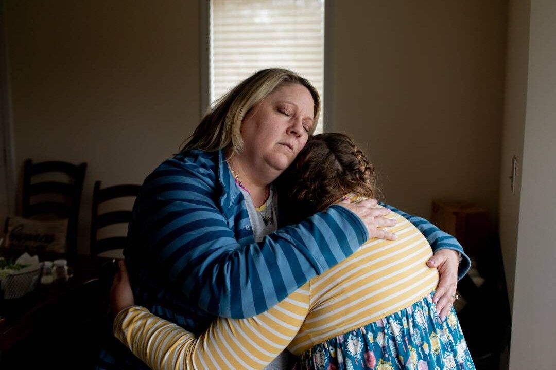 Amy Cupp hugs her daughter, G, for a portrait in her home in northern Indiana. G is 12 and has multiple disabilities. 