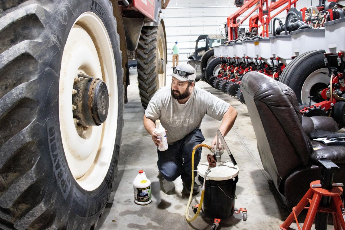Northern Vanderburgh County Kron Farms Manager Ben Kron is lubricating the hubs of their sprayer, as part of routine winter maintenance projects