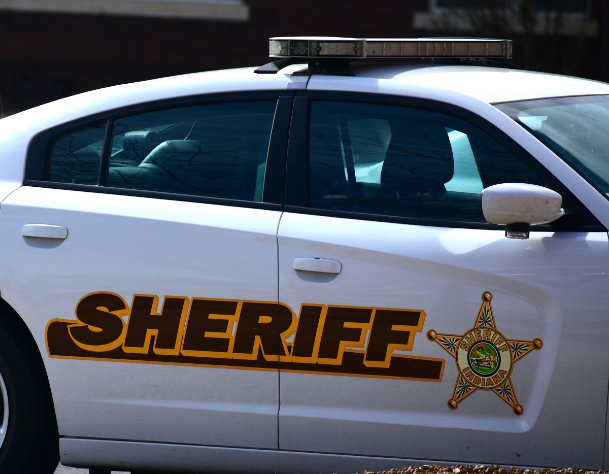 A law enforcement vehicle with "Sheriff" and a star symbol along its side.