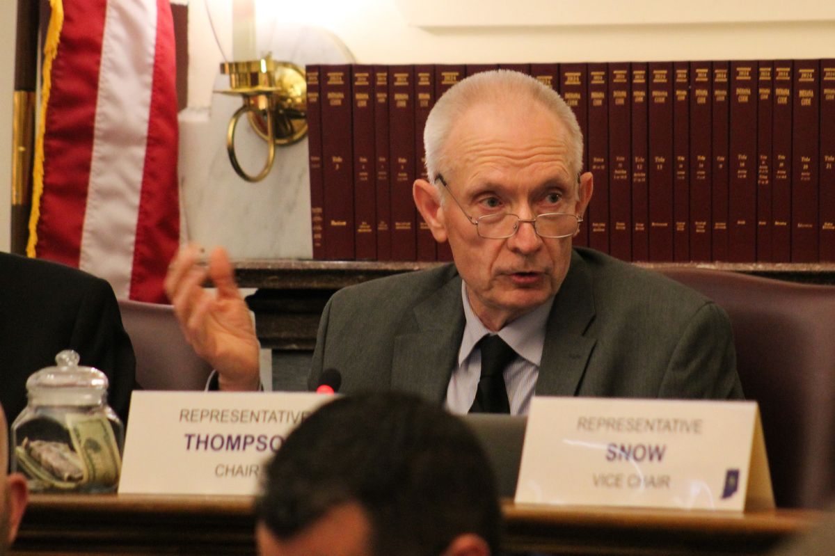 Representative Jeff Thompson is a White man with short white hair. He sits at a desk in the House Ways and Means Committee room. Legal books are lined behind him and he wears a suit and glasses.