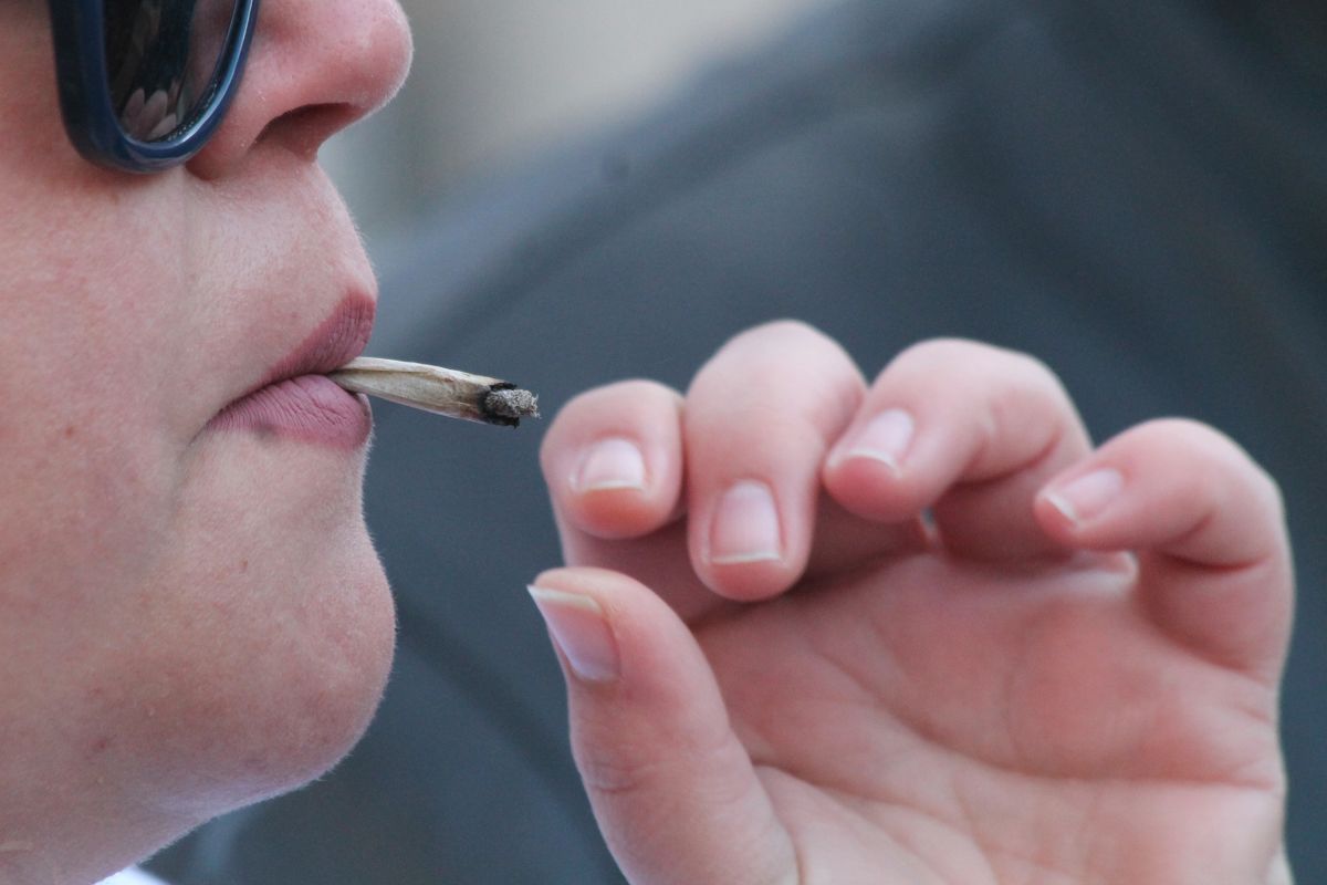 person with sunglasses smoking marijuana close-up generic