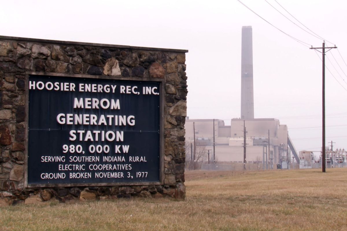 A green sign with white letters placed within a brick facade reads "Merom Generating Station".