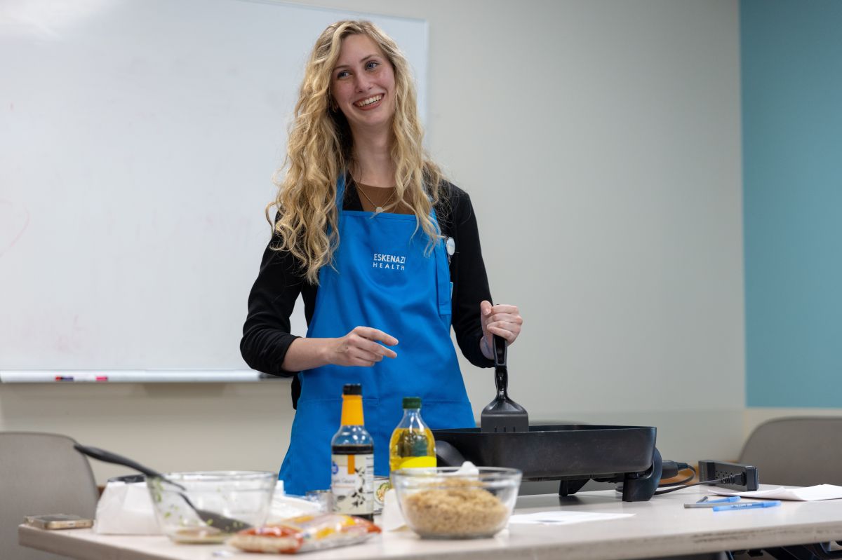 Paige Moore leads a demonstration during her internship. She wears a blue apron from Eskenazi Health.