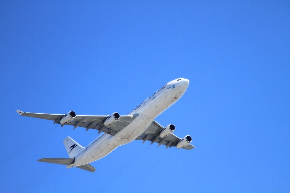 A stock image of a plane flying against a blue sky.