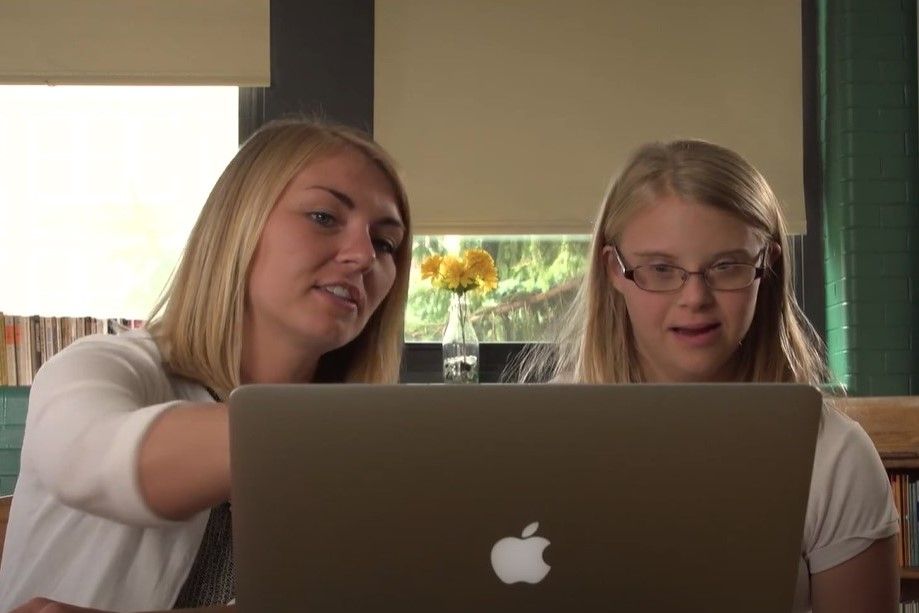 young teacher teaches student with laptop