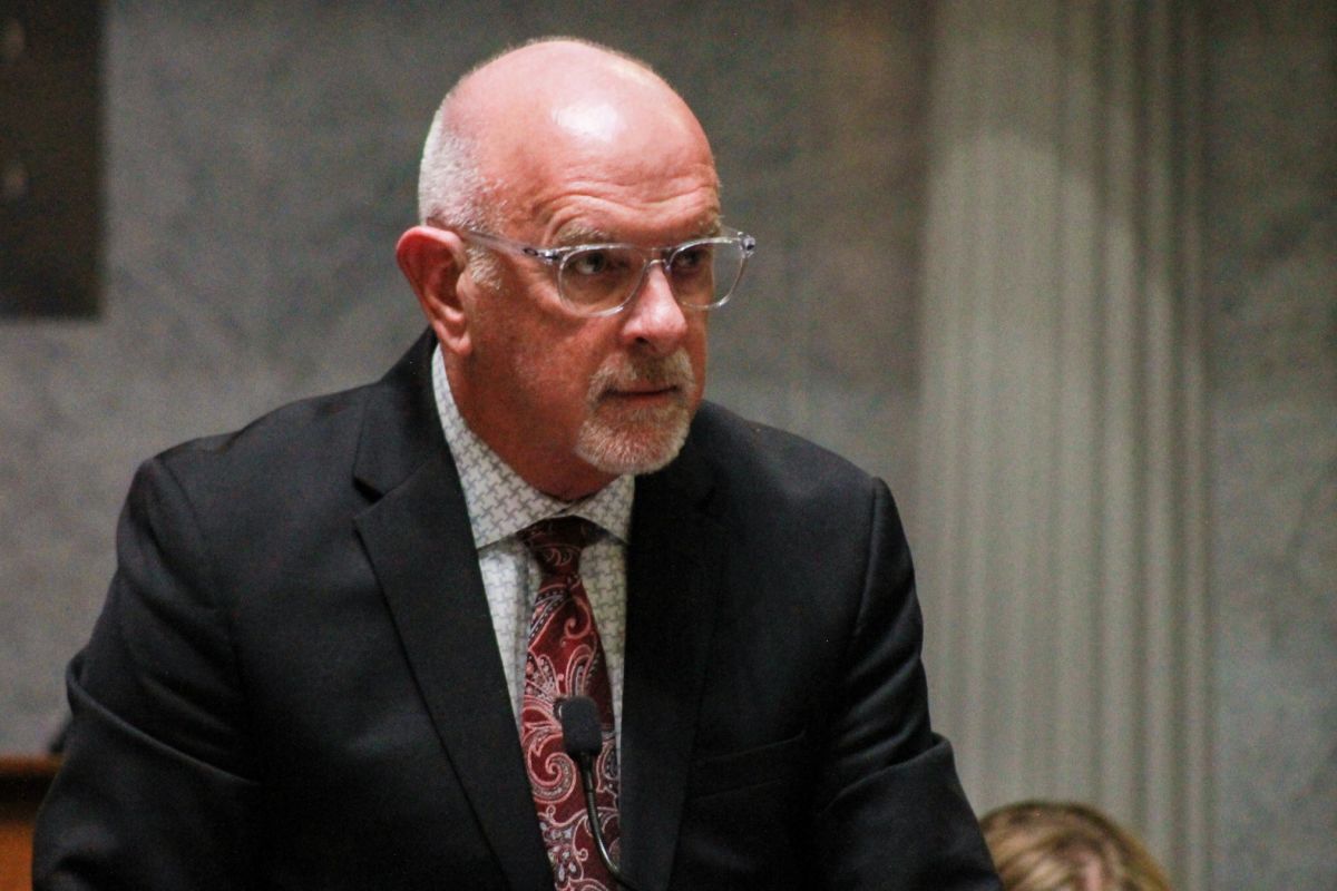 Travis Holdman is a White man, bald with a white goatee. He is wearing glasses and a suit and tie.
