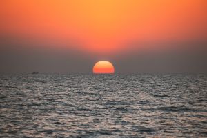 Sundown Above Sea Horizon At Sunset. Natural Sunrise Sky Warm Colors Over Ocean