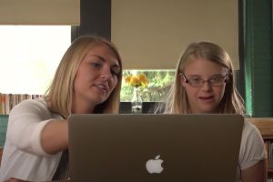 young teacher teaches student with laptop