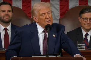 There is an American flag in front of a black curtain. There is a white woman with blonde hair speaking at a podium with a nearby screen that reads &amp;amp;quot;The Gap-Indiana 2025 report release&amp;amp;quot;. 